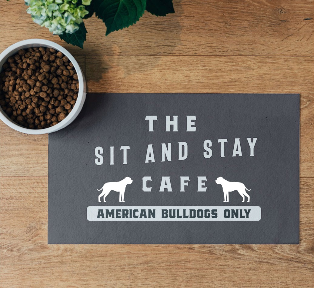 'Sit and Stay Cafe' Feeding Mat - flatlay on wooden floor with bowl