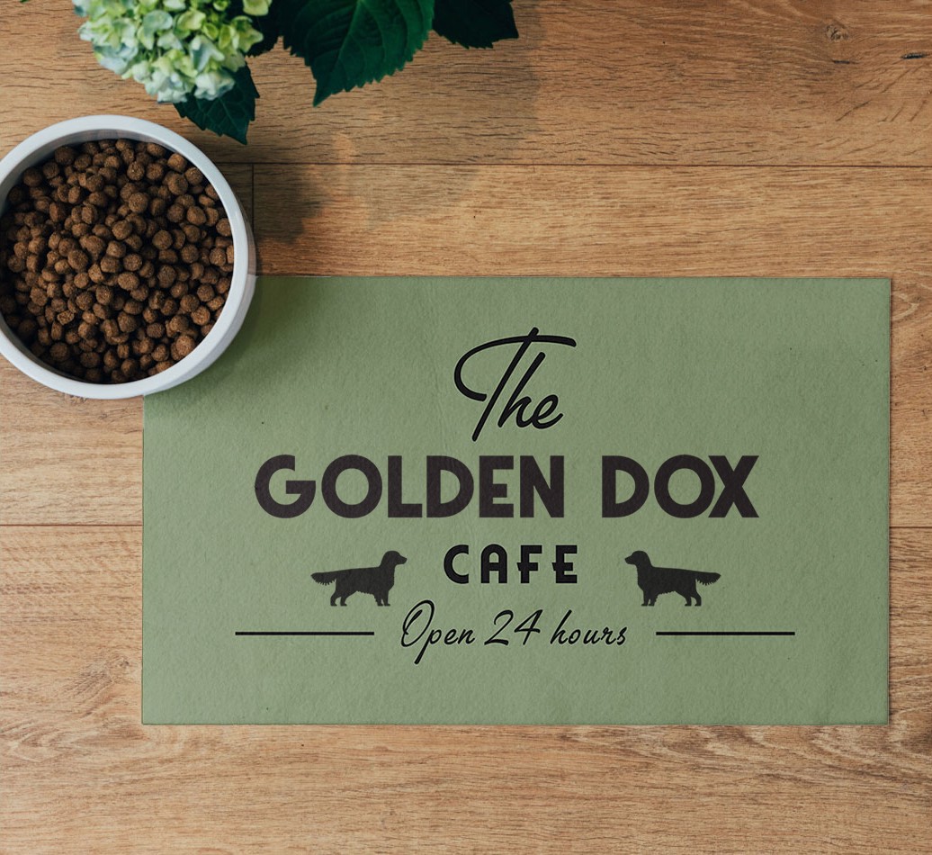 'The {breedFullName} Cafe' Feeding Mat - flatlay on wooden floor with bowl