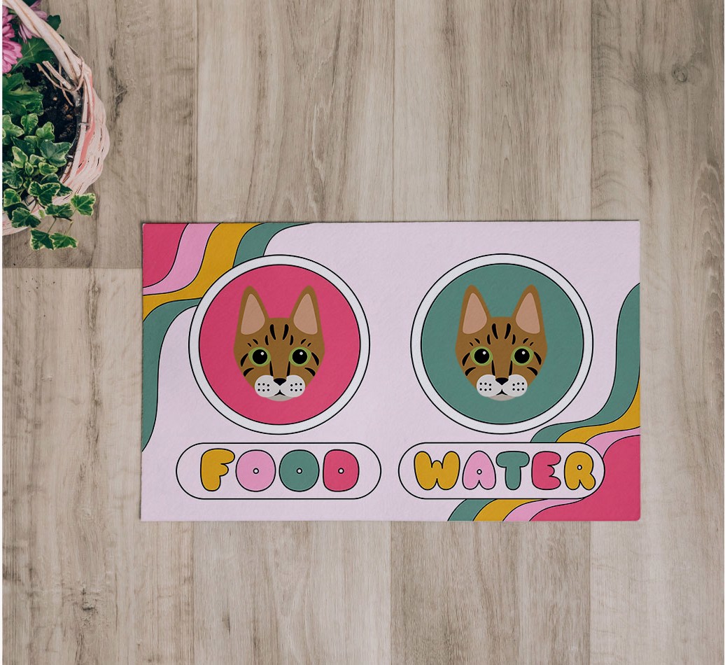 'Rainbow Icons' Feeding Mat - flatlay on wooden floor with bowl