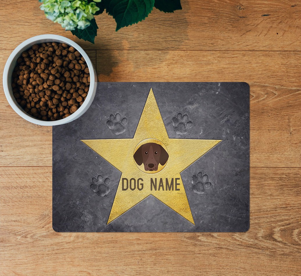 Star of Fame: Personalised {breedFullName} Feeding Mat - layed flat on wooden floor with bowl