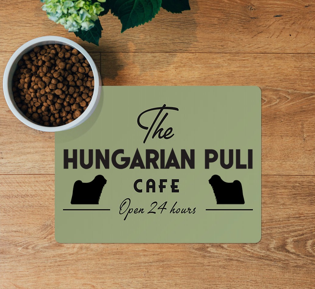 The {breedFullName} Cafe: Personalised Placemat - layed flat on wooden floor with bowl