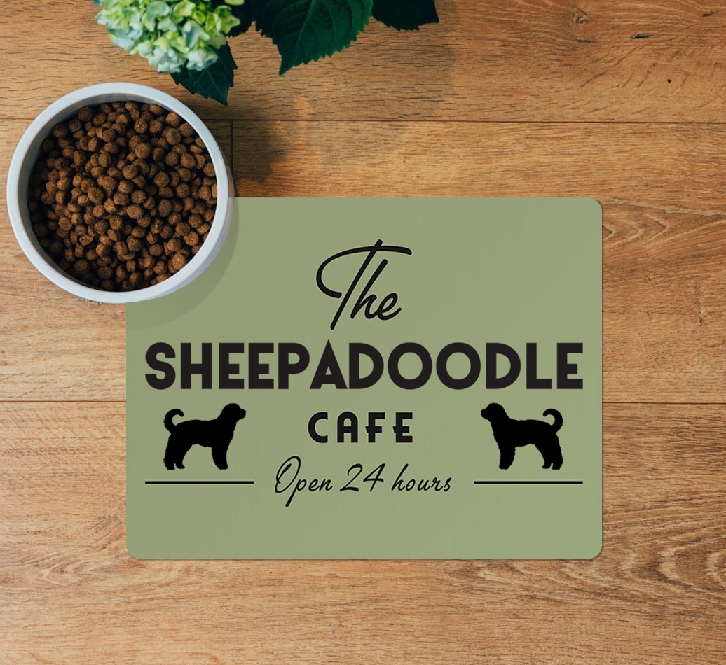 The {breedFullName} Cafe: Personalised Placemat - layed flat on wooden floor with bowl
