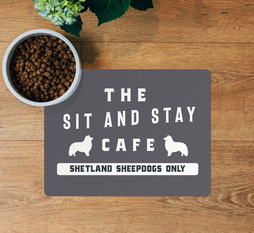 Sit and Stay Cafe: Personalised {breedFullName} Feeding Mat - layed flat on wooden floor with bowl