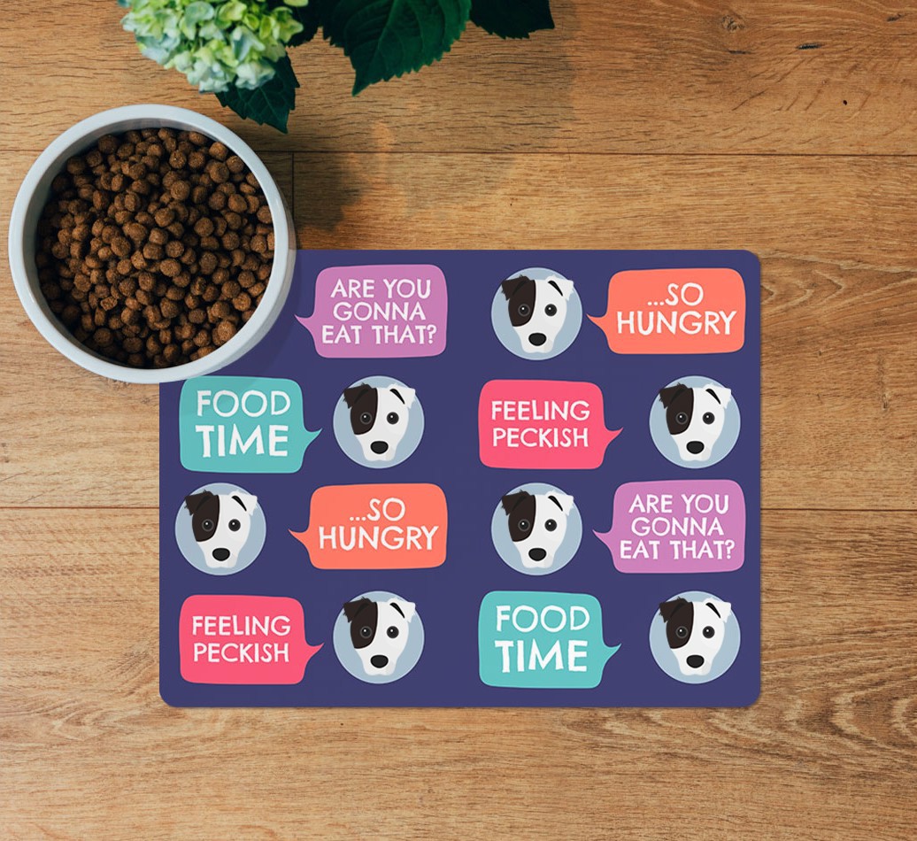 Speech Bubbles: Personalised {breedFullName} Feeding Mat - layed flat on wooden floor with bowl