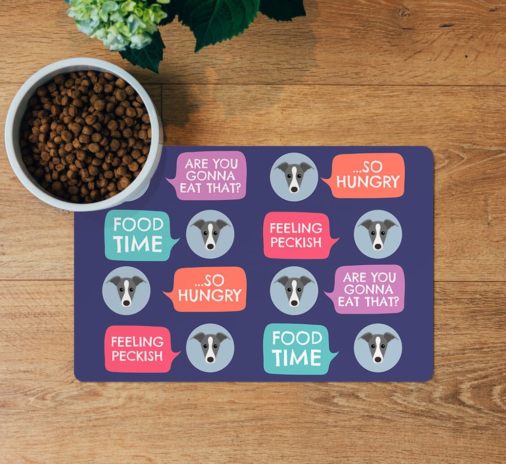 Speech Bubbles: Personalized {breedFullName} Feeding Mat - layed flat on wooden floor with bowl