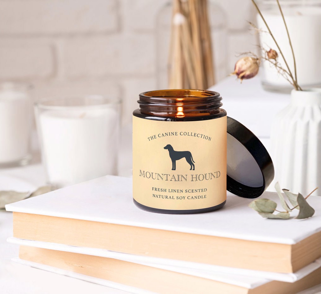 The {breedFullName} Canine Collection: Personalised Candle - on books on a bedside table